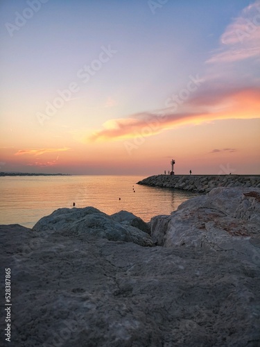 Vertical shot of a pink sunset over the coast of Senigallia, Italy photo