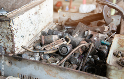 Box with spare bolts, An assortment of bolts, screws, nuts, washers and all kinds of other fasteners piled in a toolbox.