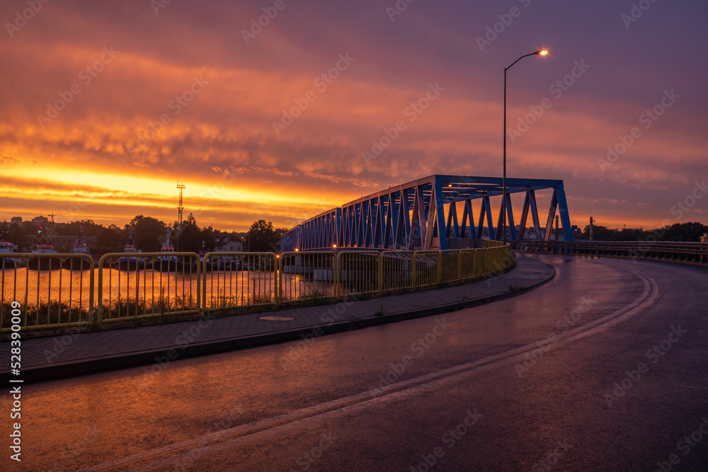 road crossing the truss bridge during an evening thunderstorm