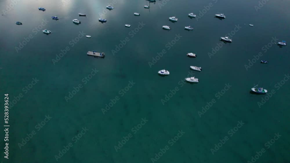 Aerial drone flying over the waters in San Vincente de la Barcera (North Spain) at dusk with dozens of boats docked. residential areas in the hills and a number of luxury hotels. 4K Videos. Aerial drone flying over the waters in San Vincente de la Barcera (North Spain) at dusk with dozens of boats docked. residential areas in the hills and a number of luxury hotels. 4K Videos.