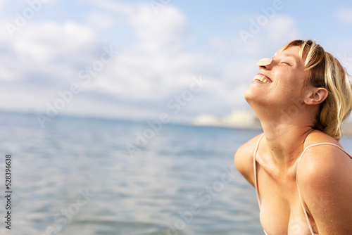Beautiful woman swimming in the ocean. Smiling blonde girl enjoy in sunny day.