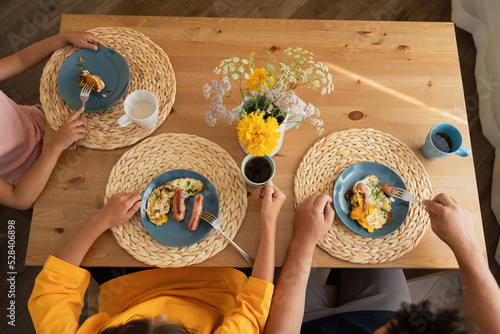 Father with daughters eating breakfast on table photo