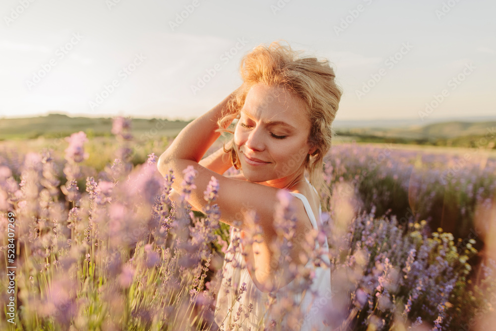 Smiling woman with eyes closed in lavender field on sunset Smiling woman with eyes closed in lavender field on sunset