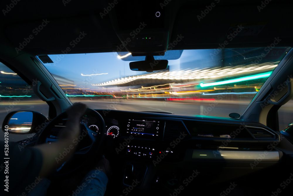 Interior view of a person driving a car with long exposure light trails. Interior view of a person driving a car with long exposure light trails.