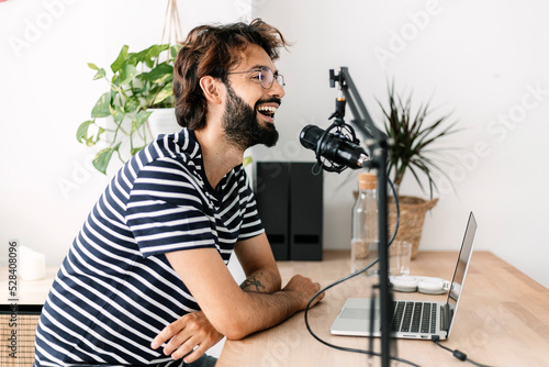 Happy content creator recording podcast in home studio