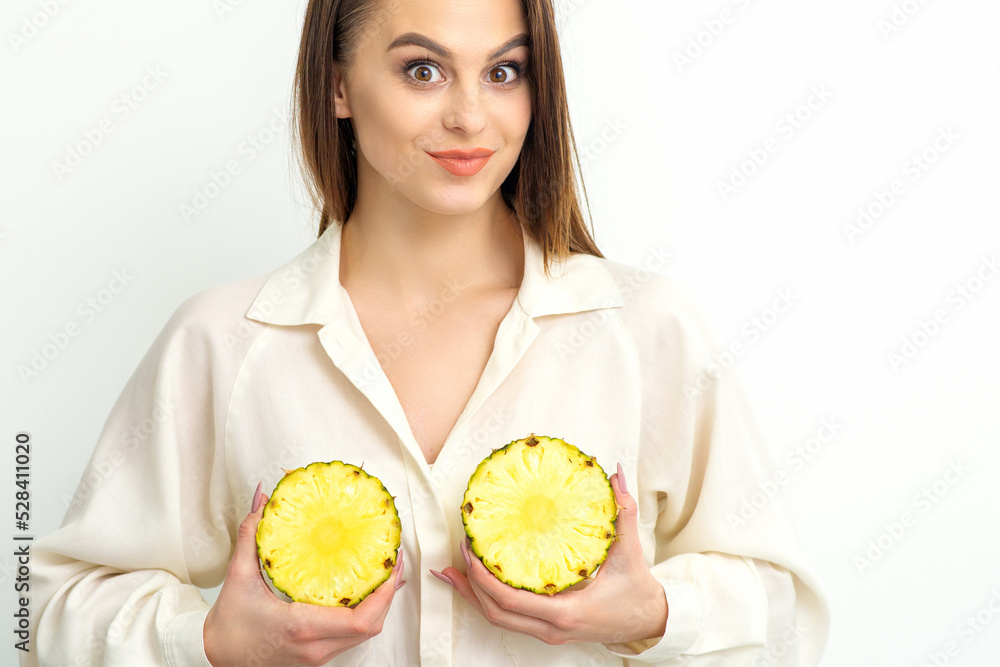 Young Caucasian smiling woman holding slices pineapple over white background, breast health concept Young Caucasian smiling woman holding slices pineapple over white background, breast health concept