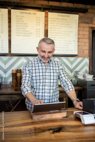 Joyous mature man working in a coffee shop