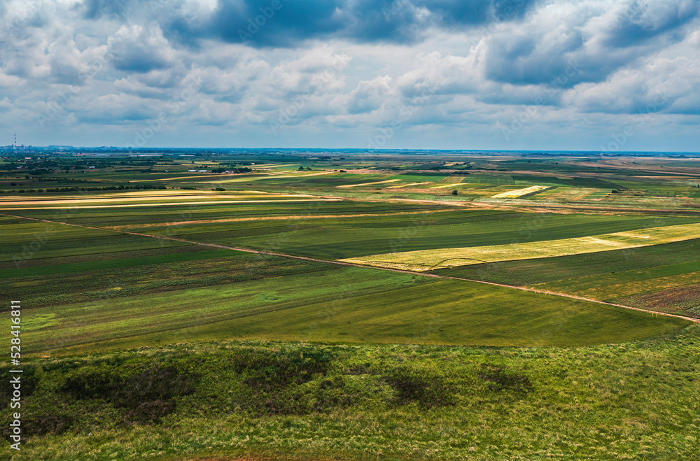 Obraz premium Aerial shot of beautiful countryside landscape with cultivated fields in Banat, geographical region of Vojvodina province in Serbia, drone pov