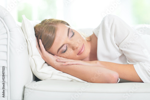 Beautiful young woman sleeping on soft bed in morning