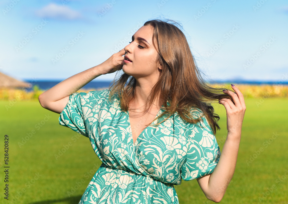 Beautiful Belarus woman against the grass with eyes closed