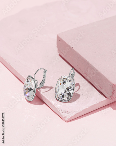  Silver earrings with round shaped white crystals and diamonds isolated on white background. Fashionable jewelry.      