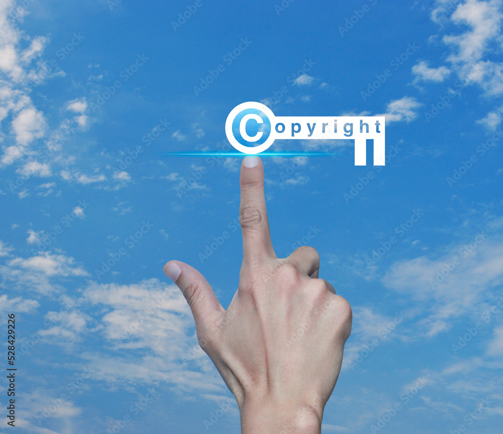 Hand pressing copyright key icon over blue sky with white clouds, Copyright and patents concept Hand pressing copyright key icon over blue sky with white clouds, Copyright and patents concept
