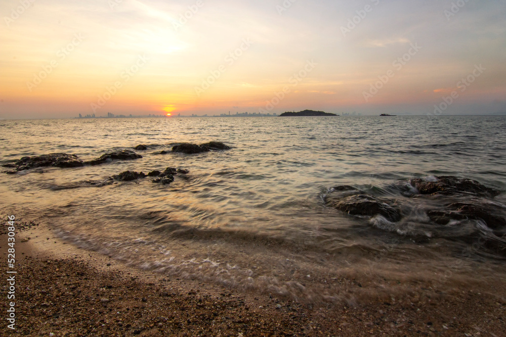 Sea beach rock stone travel island and wave with sunrise twilight morning sky background landscape in Thailand