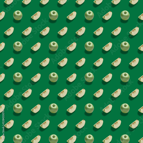 Pattern with green apples. A combination of whole and sliced apples  on a green background.