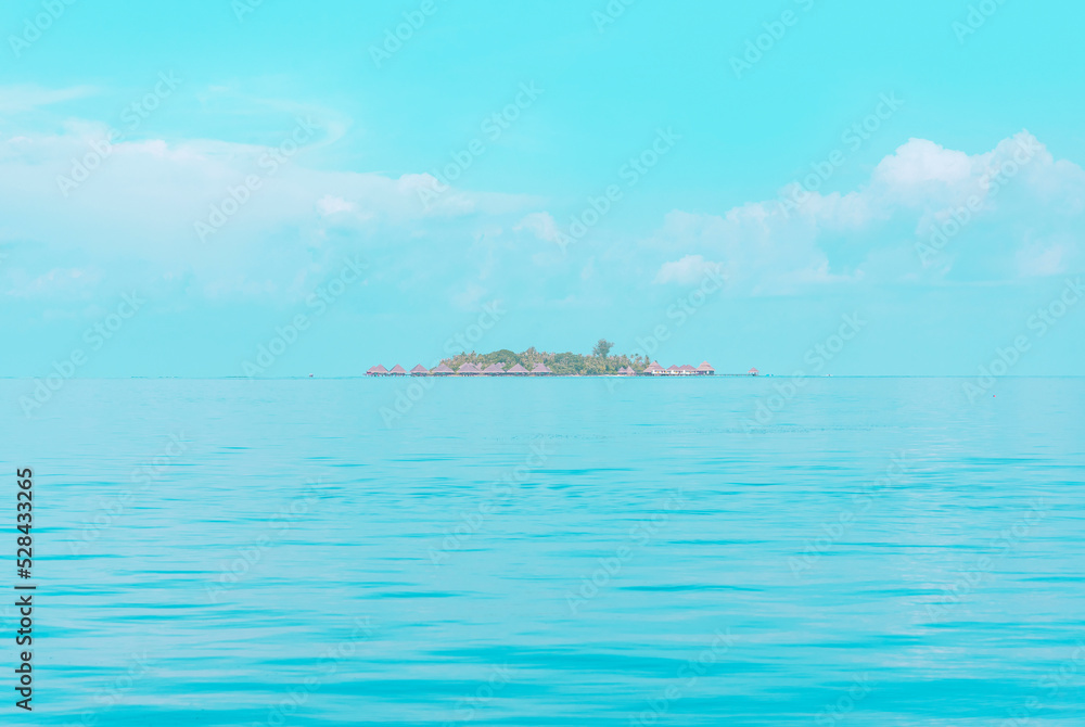 Fototapeta premium view from sea to island and water villas at day time with blue sky and beautiful clouds in the Maldives, the concept of luxury travel