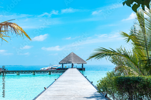 Fototapeta Naklejka Na Ścianę i Meble -  wooden pier in the sea at day time with blue sky and beautiful clouds in the Maldives, the concept of luxury travel