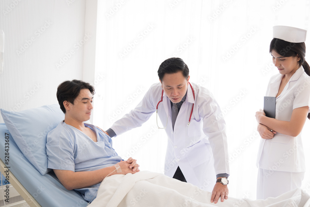 Obraz premium Doctor in professional working uniform taking care his patient and diagnosis symptoms on the bed.