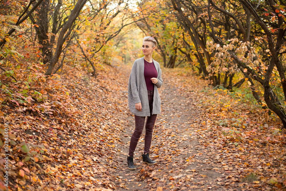 happy young woman in autumn forest background with golden and red trees happy young woman in autumn forest background with golden and red trees