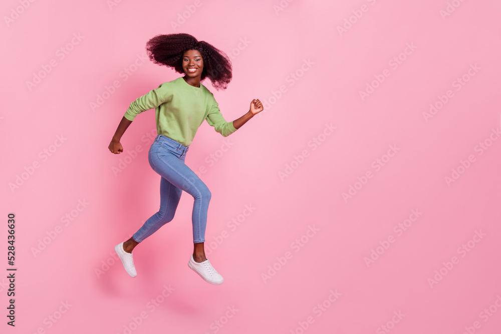 Full length photo of sweet shiny girl dressed green pullover running fast jumping high empty space isolated pink color background