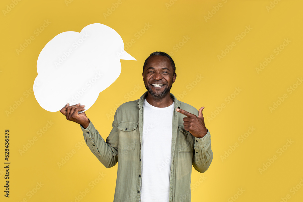 Happy middle aged african american man in casual pointing finger to abstract bubble cloud for words and thoughts Happy middle aged african american man in casual pointing finger to abstract bubble cloud for words and thoughts