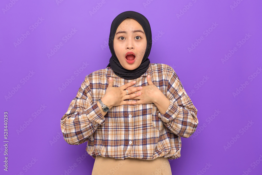 Amazed young Asian woman in plaid shirt hands on chest, looking at camera with wow face expression isolated on purple background Amazed young Asian woman in plaid shirt hands on chest, looking at camera with wow face expression isolated on purple background