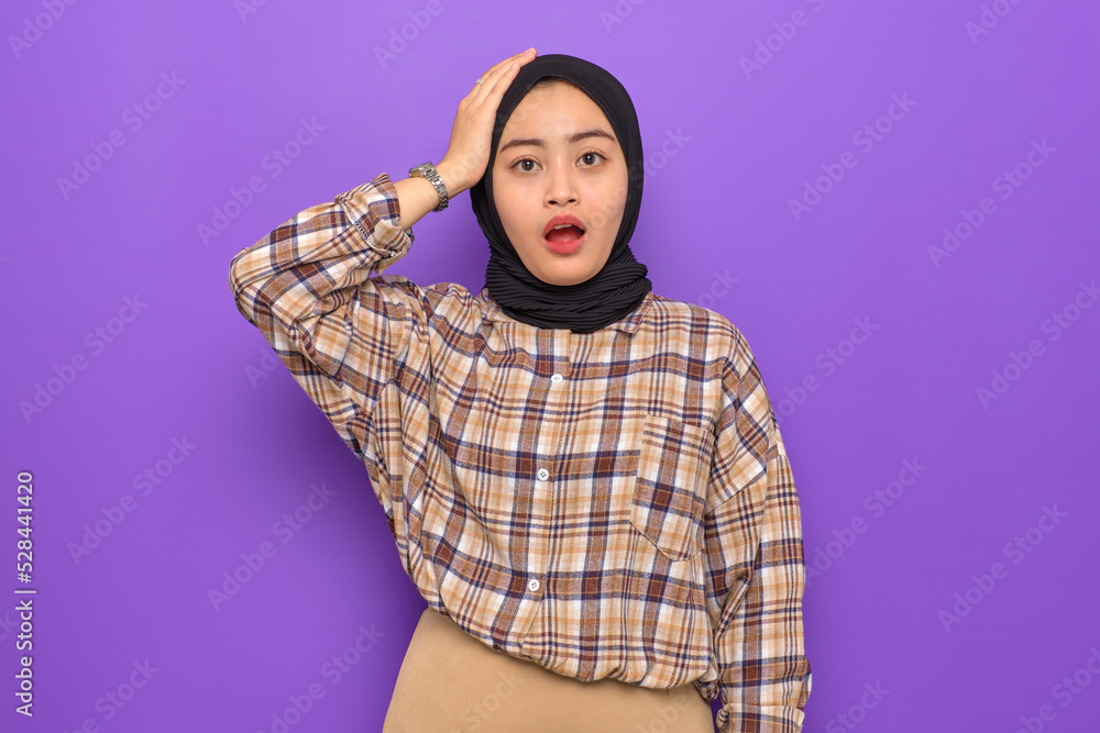 Amazed young Asian woman in plaid shirt looking at camera with wow face expression isolated on purple background Amazed young Asian woman in plaid shirt looking at camera with wow face expression isolated on purple background