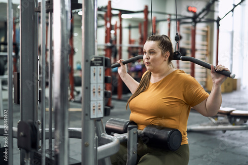 Woman with overweight make a workout at the gym