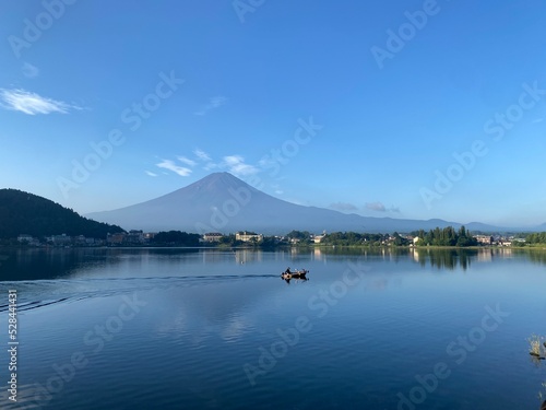 Boat ride across the lake Kawaguchiko with beautiful clear Mt. Fuji view, sunny day with blue sky and the clear tip of the mountain, year 2022 August 27th, 6:27am Yamanashi prefecture, Japan 