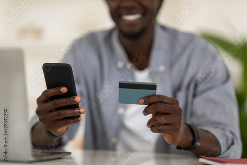 Unrecognizable Black Man Making Online Payments With Smartphone And Credit Card