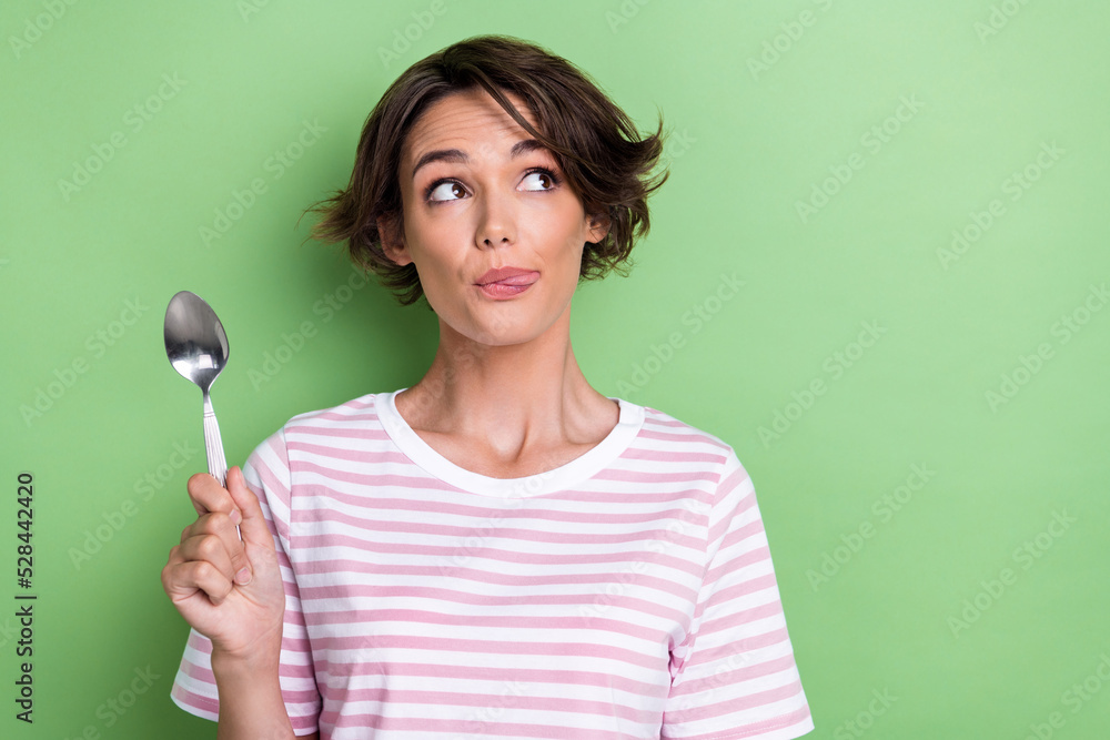 Closeup photo of young adorable gorgeous pretty girl childish look curious empty space tongue out hold spoon delicious isolated on green color background Closeup photo of young adorable gorgeous pretty girl childish look curious empty space tongue out hold spoon delicious isolated on green color background