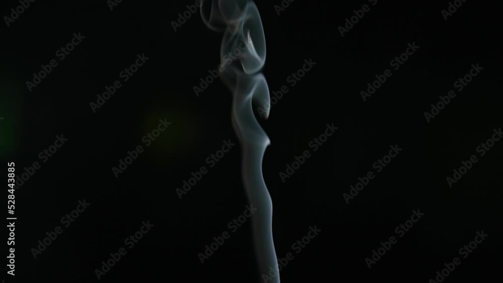White smoke from incense stick flowing on black background White smoke from incense stick flowing on black background