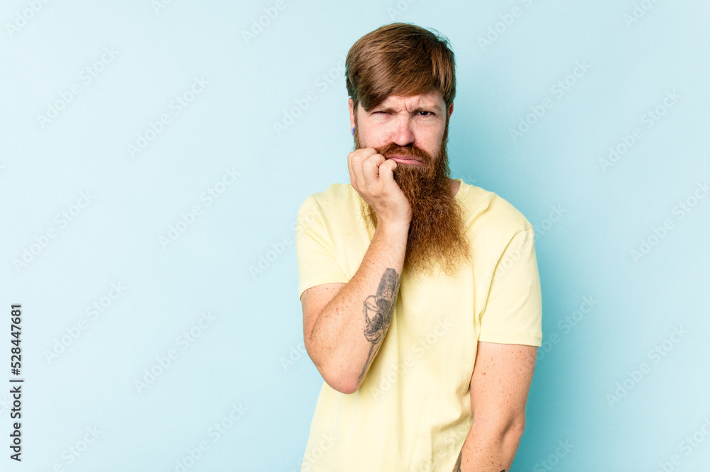 Young caucasian red-haired man isolated on blue background who feels sad and pensive, looking at copy space. Young caucasian red-haired man isolated on blue background who feels sad and pensive, looking at copy space.