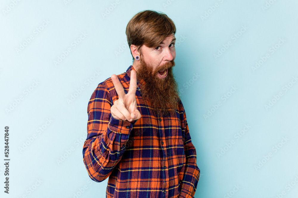 Young caucasian red-haired man isolated on blue background showing number two with fingers. Young caucasian red-haired man isolated on blue background showing number two with fingers.