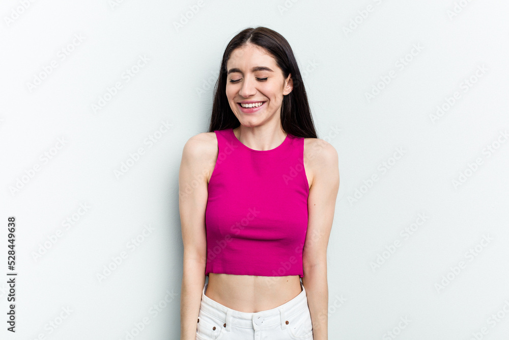 Young caucasian woman isolated on white background laughs and closes eyes, feels relaxed and happy. Young caucasian woman isolated on white background laughs and closes eyes, feels relaxed and happy.