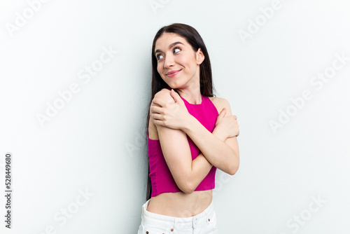 Young caucasian woman isolated on white background hugs, smiling carefree and happy. © Asier