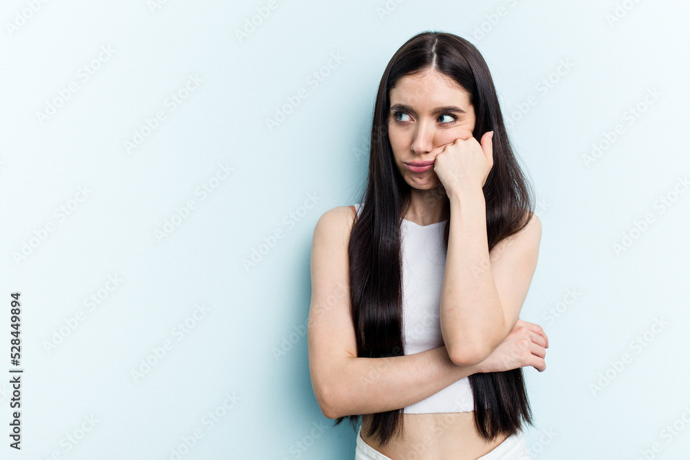 Young caucasian woman isolated on blue background who feels sad and pensive, looking at copy space. Young caucasian woman isolated on blue background who feels sad and pensive, looking at copy space.