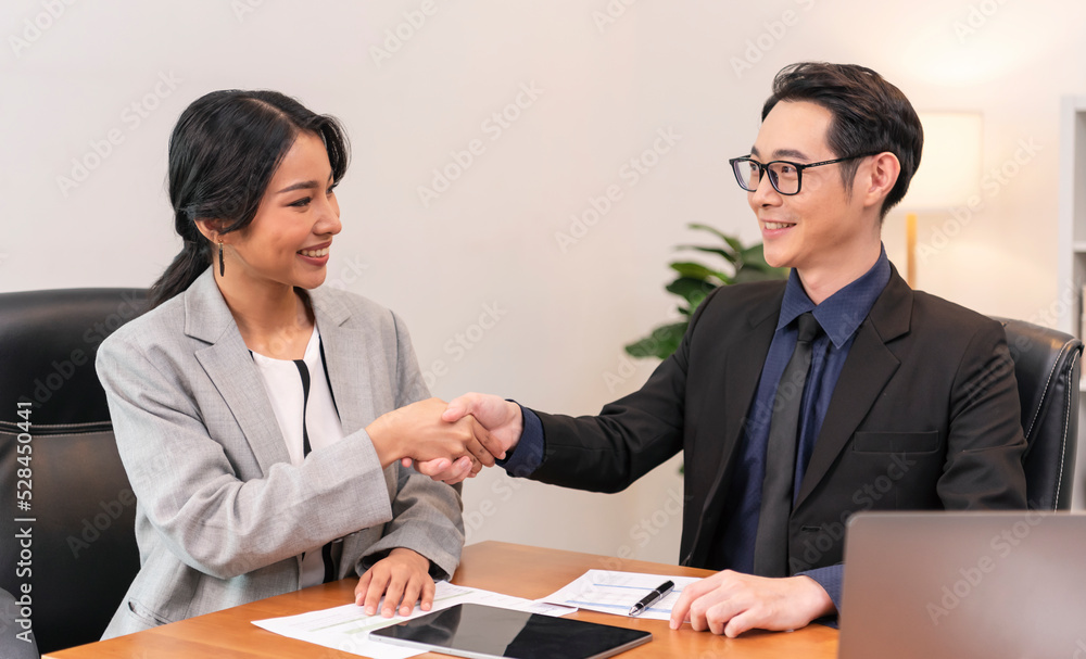Asian businesspeople shake hands starting collaboration at negotiations, positive businesspeople gathered at office boardroom, partnership teamwork. Asian businesspeople shake hands starting collaboration at negotiations, positive businesspeople gathered at office boardroom, partnership teamwork.