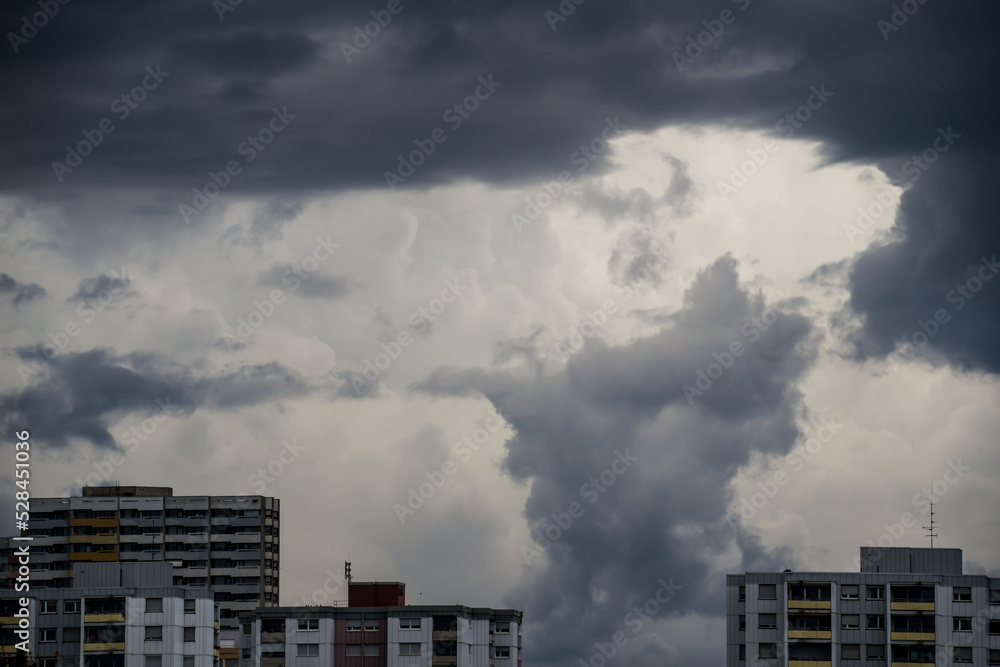 Dark thunder clouds over city buildings Dark thunder clouds over city buildings