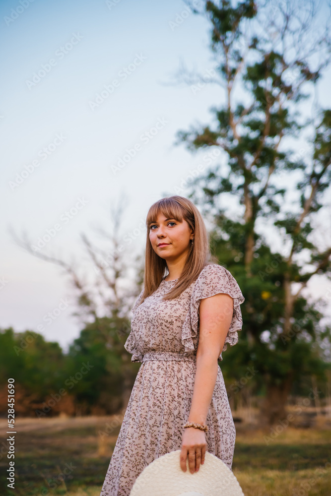 A young woman in a hat in a clearing. A walk in the park or forest. Outdoor recreation. The atmosphere of freedom and tranquility. A young woman in a hat in a clearing. A walk in the park or forest. Outdoor recreation. The atmosphere of freedom and tranquility.