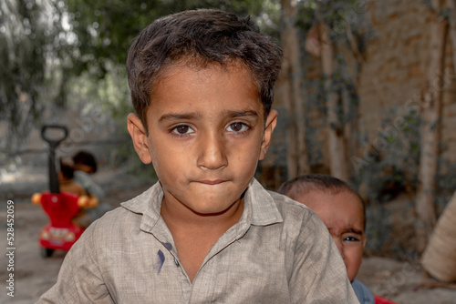 a child with a sad expression cause of flood and homelessness situation photo
