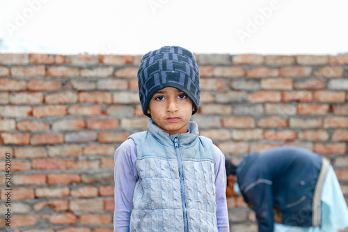 a child with a sad expression cause of flood and homelessness situation photo