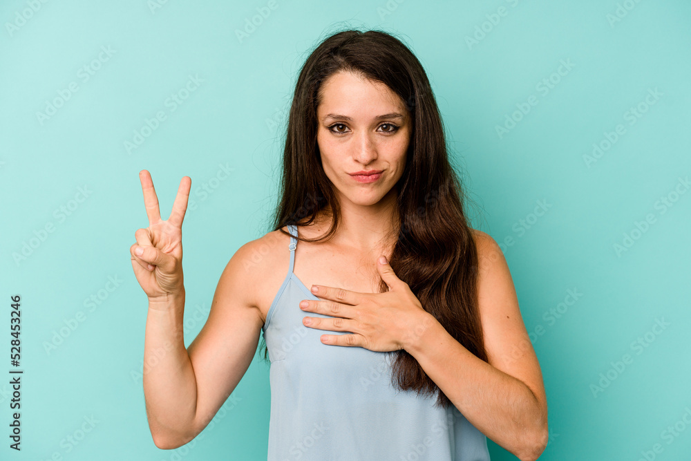 Young caucasian woman isolated on blue background taking an oath, putting hand on chest. Young caucasian woman isolated on blue background taking an oath, putting hand on chest.