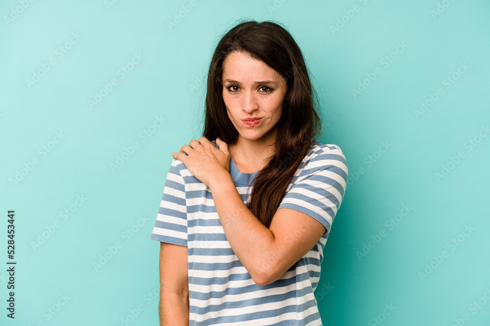 Young caucasian woman isolated on blue background having a shoulder pain. Young caucasian woman isolated on blue background having a shoulder pain.