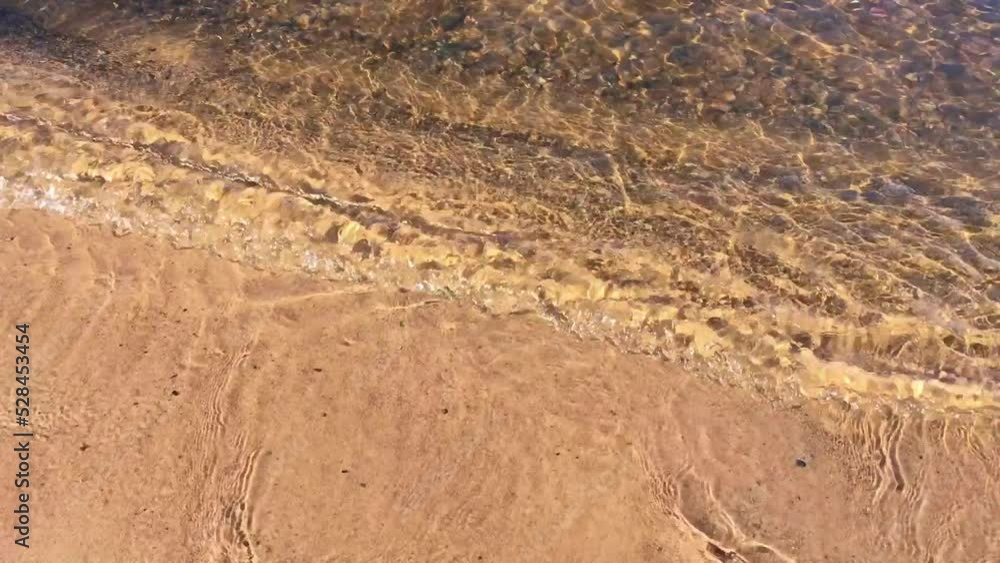 Waves on the lake with transparent water and stones at the bottom. Waves on the lake with transparent water and stones at the bottom.