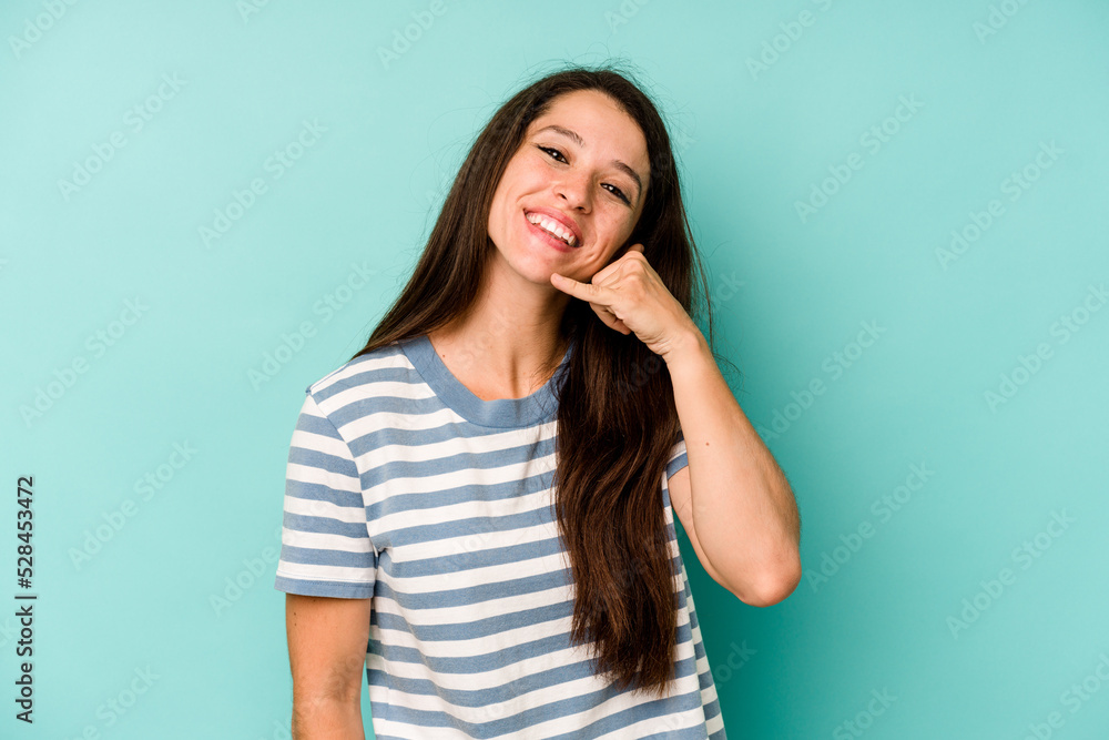 Young caucasian woman isolated on blue background showing a mobile phone call gesture with fingers. Young caucasian woman isolated on blue background showing a mobile phone call gesture with fingers.