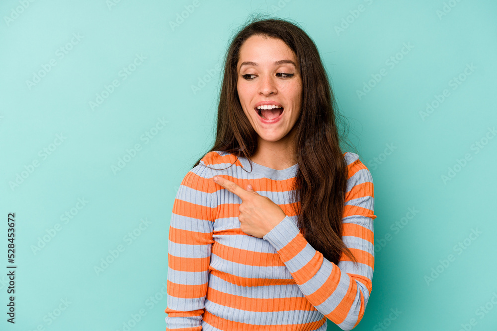 Young caucasian woman isolated on blue background looks aside smiling, cheerful and pleasant. Young caucasian woman isolated on blue background looks aside smiling, cheerful and pleasant.