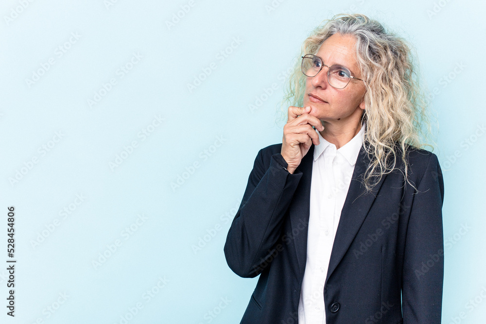 Middle age caucasian business woman isolated on blue background looking sideways with doubtful and skeptical expression. Middle age caucasian business woman isolated on blue background looking sideways with doubtful and skeptical expression.