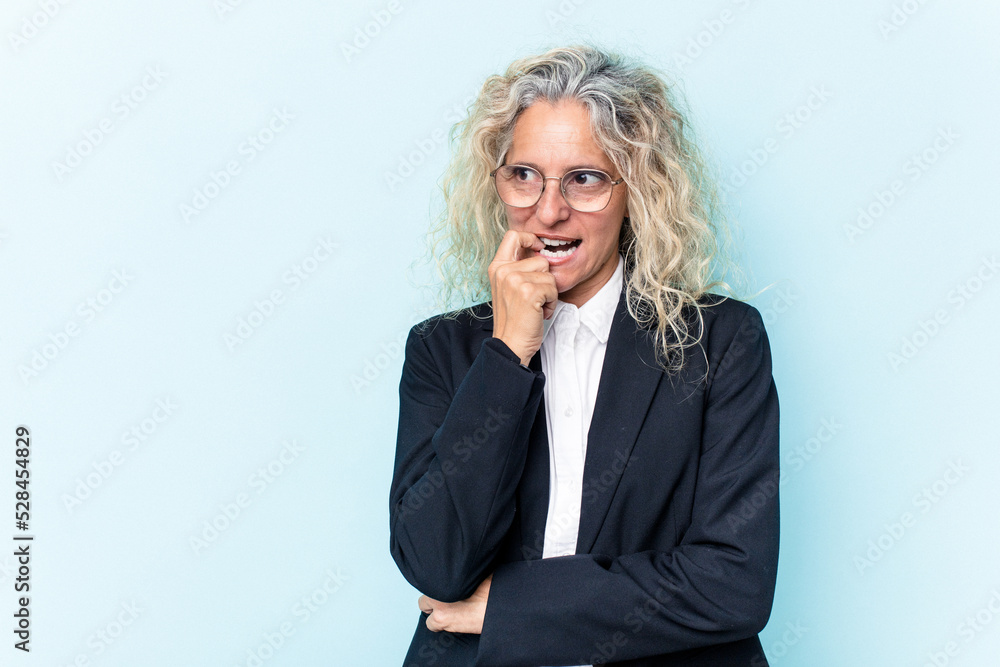 Middle age caucasian business woman isolated on blue background relaxed thinking about something looking at a copy space. Middle age caucasian business woman isolated on blue background relaxed thinking about something looking at a copy space.