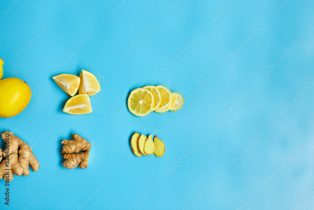 Flat lay of Immune boosting remedy, immunity boosting foods ginger and lemon on blue background Top view, copy space Flat lay of Immune boosting remedy, immunity boosting foods ginger and lemon on blue background Top view, copy space