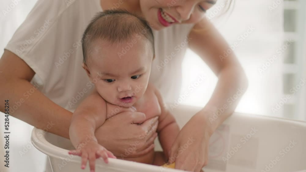 young Asian mother is Bathing with her newborn baby In Bathtub at home.Concept of newborn,baby,parenthood,motherhood,childhood,New life,maternity,love,new family member young Asian mother is Bathing with her newborn baby In Bathtub at home.Concept of newborn,baby,parenthood,motherhood,childhood,New life,maternity,love,new family member
